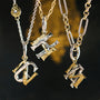 Three gold necklaces with unique pendants on a dark background-3