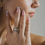 Close-up of a woman's hand with rings on her fingers, touching her face.-2